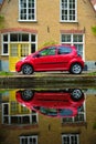 Red car on canal embankment in street of Delft. Delft, Netherlands Royalty Free Stock Photo