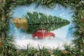 Red car carrying christmas tree with frame Royalty Free Stock Photo
