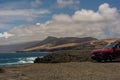 A red car on the coast of Fuerteventura with a view of the Atlantic