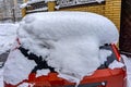 A red car covered in snow on the side of a street Royalty Free Stock Photo