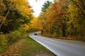 Red Car Driving on a Curvy Road with Fall Foliage Royalty Free Stock Photo