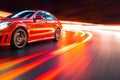 a red car driving down a city street at high speed with motion blurs on the road and the car lights streaking behind it Royalty Free Stock Photo