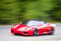 Red car driving fast on country road Royalty Free Stock Photo