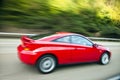 Red car driving fast on country road Royalty Free Stock Photo