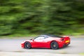 Red car driving fast on country road Royalty Free Stock Photo