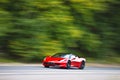 Red car driving fast on country road Royalty Free Stock Photo