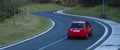 Red car driving fast on the curve of road