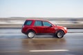 The red car is driving at high speed on the road in the city. Bl Royalty Free Stock Photo