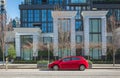 Red car on the empty urban street in a sunny day. Car parked in downtown of Vancouver. Modern architecture and a car Royalty Free Stock Photo