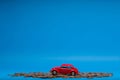 Chisinau 20.02.2020:Red car figurine placed on top of a heap of golden coins, on blue background