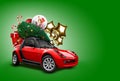 Red car on green background. Christmas tree, presents, balloons in form of golden stars, snow globe, candies on roof Royalty Free Stock Photo