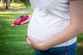 The red car in the hand of a pregnant woman Royalty Free Stock Photo