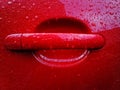 Red car handle  covered with rain drops Royalty Free Stock Photo