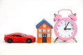 Red car and house model with alarm clock. Royalty Free Stock Photo