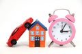 Red car and house model with alarm clock. Royalty Free Stock Photo