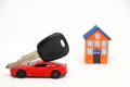 Red car with key with house model in background. Royalty Free Stock Photo