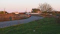 A red car makes a bend in the road.