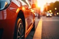 Red car parked on roadside with blurred night city lights background at dark evening time, back view Royalty Free Stock Photo