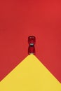Red car is on rend and yellow abstract background with reflector on the road.
