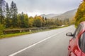 Red car on the road in autumn mountains. Travel in Carpathian mountains, Ukraine. Car on curve highway on forest background. Royalty Free Stock Photo