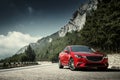 Red car standing on the road near mountains at daytime Royalty Free Stock Photo