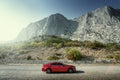 Red car standing on the road near mountains at daytime Royalty Free Stock Photo