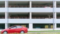 Red car stands on asphalt road against white vehicle