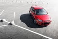 Red car stay on asphalt parking at daytime