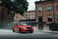 Red car stay on asphalt road in the city at daytime Royalty Free Stock Photo