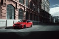 Red car stay on asphalt road in the city at daytime Royalty Free Stock Photo