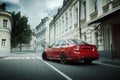 Red car stay on asphalt road in the city at daytime Royalty Free Stock Photo