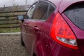 Red car with stop light on, rear view. Royalty Free Stock Photo