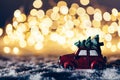 Red car with a tree driving through snowy road. Royalty Free Stock Photo