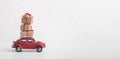 Red car Volkswagen Beetle car carrying Christmas gift boxes on white