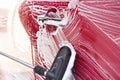 Red car washed in self serve carwash , detail on brush leaving strokes on side door, wide banner with empty space for Royalty Free Stock Photo