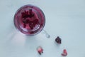 Red carcade tea in transparent glass cup at white wooden background Royalty Free Stock Photo