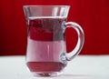 Red carcade tea in transparent glass cup at white wooden background Royalty Free Stock Photo