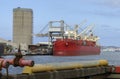 A red cargo ship loading freight at Newcastle docks. Royalty Free Stock Photo