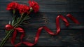 Red carnations with ribbon on a wooden background Royalty Free Stock Photo