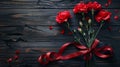 Red carnations with ribbon on a wooden background Royalty Free Stock Photo