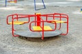 Red carousel in the playground. The concept of childhood, parenting, games.