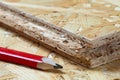 Red carpenter pencil lying next to tongue and groove chip board. Blurred background Royalty Free Stock Photo