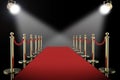 Red carpet and rope barrier with shining spotlights