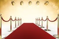 Red carpet and rope barrier with shining spotlights