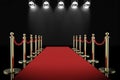 Red carpet and rope barrier with shining spotlights