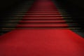 Red carpet on the stairs on a dark background. The path to glory, victory and success