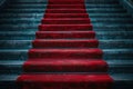 Red carpet on the stairs on a dark background. The path to glory, victory and success Royalty Free Stock Photo