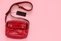 Red carry bag with black price tags on pink background.