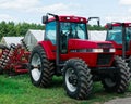 Red Case tractor and cultivator parked on farm Royalty Free Stock Photo