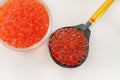 Red caviar in a bowl with wooden spoon over white background Royalty Free Stock Photo